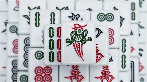 Close-up arrangement of Mahjong tiles featuring red, green and black symbols