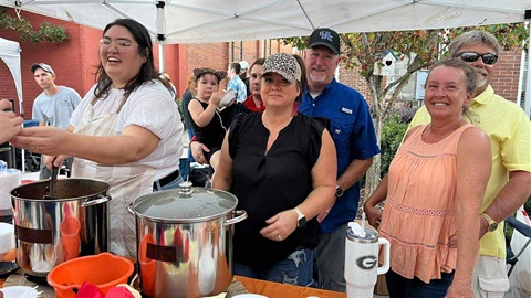 Large group of people waiting for chili at a booth