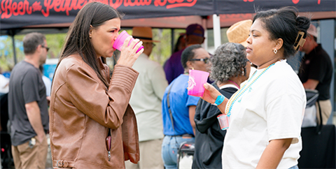 Two ladies enjoying a pink cup of refreshment