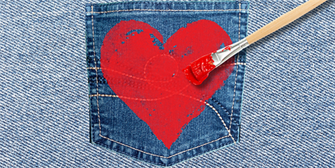 Graphic of blue jean pocket with a red heart and art brush over a denim background